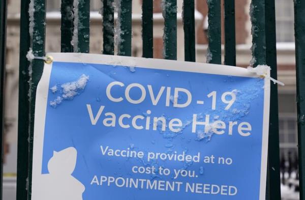 FILE - A sign covered with ice advertises a COVID-19 vaccination site in New York, Tuesday, Feb. 2, 2021.  On Friday, Nov. 17, 2023, The Associated Press reported on stories circulating online incorrectly claiming  over-the-counter cold and cough medications are being pulled from drugstore shelves in an effort to start the “next plandemic” or force people to get the COVID-19 vaccine. (AP Photo/Seth Wenig, File)