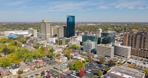 Aerial drone view of downtown Lexington, Kentucky with tall buildings and trees on a sunny Fall day
