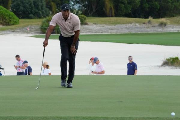 Tiger Woods在第三个果岭上研究他的推杆